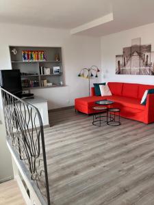 卢贝新城2 pièces rez-de-jardin dans maison avec piscine的客厅配有红色的沙发和桌子