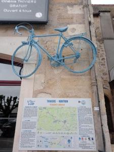 Saint-Front-la-RivièreMaison de location saisonnière en Périgord Vert的挂在建筑物边的蓝色自行车