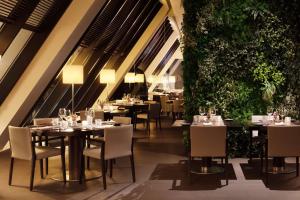 维拉摩拉维拉摩拉码头宏福酒店的一间设有桌椅的餐厅,种植了植物