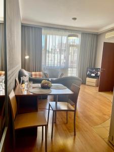 敖德萨阿卡达公寓酒店的客厅配有桌子和沙发