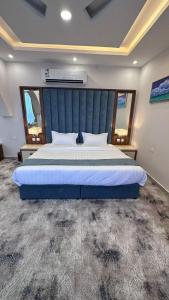 乌姆莱季SEAVIEW HOTEL的一间卧室配有一张大床和蓝色床头板