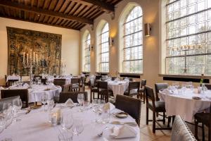 旧蒂尔瑙特普瑞姬科森多克酒店的餐厅设有白色的桌椅和窗户。