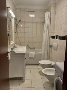 敖德萨阿卡达公寓酒店的一间带水槽、卫生间和淋浴的浴室