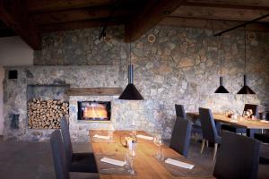 皮茨河谷阿兹尔Puitalm - Natur I Apart I Hotel的一间设有桌子和石墙的用餐室