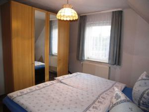 特拉森海德Ferienwohnung Heimann的一间卧室配有一张床和一个吊灯