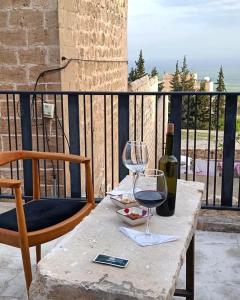 马尔丁TUĞMANER Small House AJAR的一张桌子,上面放着一杯葡萄酒和一瓶