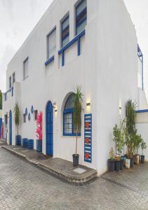 MukāwirLara Family Resorts的白色的建筑,前方有蓝色的门和棕榈树