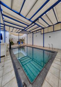 MukāwirLara Family Resorts的一个带蓝色横梁的室内游泳池