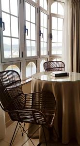 奥巴尔克伊洛Hostal O Forno的一张桌子、两把椅子和一张桌子及窗户