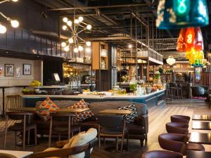 阿姆斯特丹阿姆斯特丹中心宜必思酒店的一间带桌椅的餐厅和一间酒吧