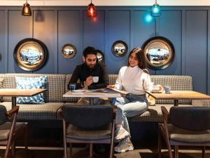阿姆斯特丹阿姆斯特丹中心宜必思酒店的坐在餐厅桌子上的男女