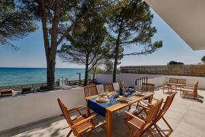 阿里克斯Vera Villa - Brand New Seafront Villa!的一个带桌椅的庭院和大海