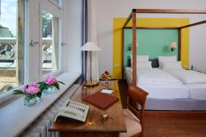 德累斯顿艾克城堡酒店的酒店客房配有一张床、一张书桌