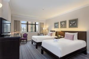 曼谷The Sukosol Hotel的酒店客房设有两张床和一台平面电视。