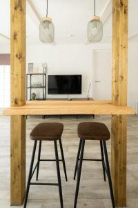 贝尼多姆Apartamento ALMA con terreno privado y parking compartido - a 800m de Playa Poniente的厨房配有木桌和2个吧台凳