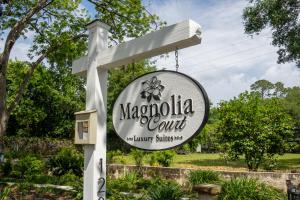 博福特Magnolia Court Suites的花园内木兰花球场的标志
