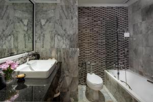 曼谷The Sukosol Hotel的浴室配有盥洗盆、卫生间和浴缸。