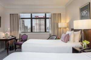 曼谷The Sukosol Hotel的配有一张床、一张书桌和一扇窗户的酒店客房