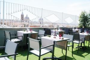 罗马环球贝斯特韦斯特优质酒店的屋顶上设有白色桌椅的餐厅