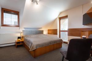 劳耶克特普利采维拉维克托利亚酒店的一间卧室配有一张床和一把椅子,还有两个窗户