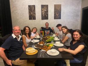 索瓦马laperla chalet villa di lusso deadsea的一群人坐在桌子旁吃着食物
