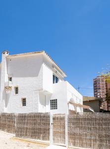 贝尼多姆Casa MYA con terreno privado y parking compartido - a 800m de Playa Poniente的围栏后面的白色房子