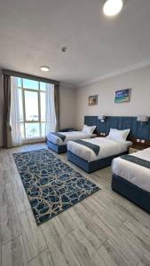 乌姆莱季SEAVIEW HOTEL的酒店客房,设有三张床和地毯。