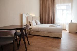 久姆里KUMA Hotel Gyumri的酒店客房配有一张床铺和一张桌子。