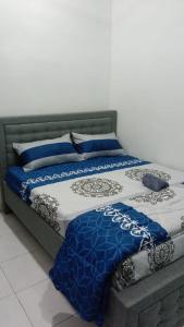加央MAS'homestay perlis的床上铺有蓝色和白色的床单