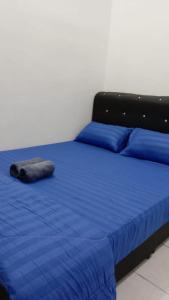加央MAS'homestay perlis的一张带蓝色床单和枕头的床