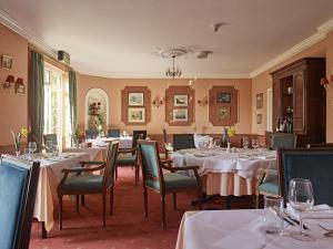 Corse科西嘉草坪别墅酒店的用餐室配有桌椅和白色的桌布