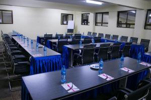 KisiiUfanisi Resort - Kisii的配有桌椅和蓝色窗帘的房间