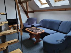 KleingießhübelFerienwohnungen Hering的客厅配有蓝色的沙发和桌子