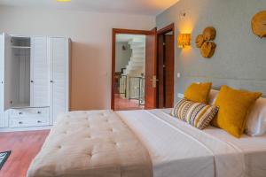 马尔马里斯Marmaris Private Villa-Villa Lufu的卧室配有一张带黄色枕头的大型白色床。