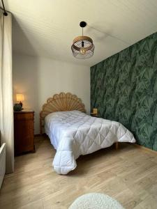 莱萨布勒-多洛讷La Maison des sables , 300m de la plage的一间卧室设有一张大床和绿色的墙壁