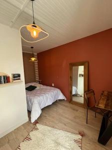 莱萨布勒-多洛讷La Maison des sables , 300m de la plage的一间卧室配有一张床、镜子和一张桌子