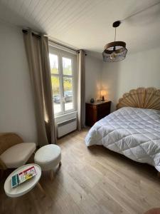 莱萨布勒-多洛讷La Maison des sables , 300m de la plage的卧室配有床、椅子和窗户。