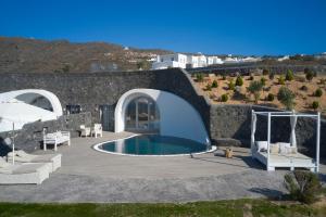 伊亚Danae Suites Santorini的一个带游泳池和房子的庭院
