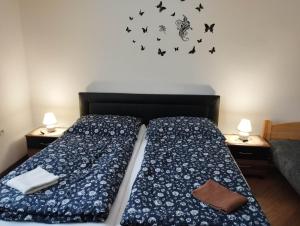 大梅杰尔Apartmán pri starom dube的一间卧室配有两张床和蝴蝶墙贴纸