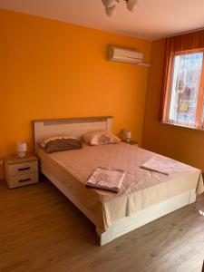 卡赞勒克Апартамент за гости ДИГЕНА的一间卧室配有一张带橙色墙壁的大床