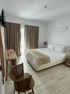 梅利迪什À Espera - Turismo Rural,Melides的一间卧室配有一张大床和一把椅子