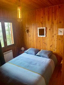 EnchastrayesLe refuge, chalet au pied des pistes au Sauze的卧室配有木墙内的一张床