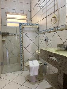 加罗帕巴Pousada Maré Mar的浴室配有卫生间、盥洗盆和淋浴。