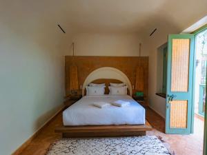 马拉喀什Riad Lalla Mimouna的卧室配有白色的床和蓝色的门