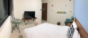 金宁乡熊宝贝民宿的一间卧室配有一张床和一台平面电视