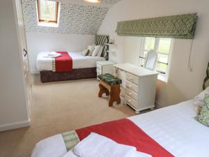 格拉斯米尔North Lodge的一间卧室配有两张床、一个梳妆台和镜子