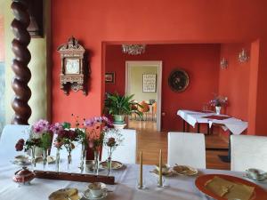 黑灵斯多夫Villa Dorothea的红色的房间,配有鲜花桌和时钟