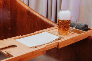 皮耶什佳尼Wellness Hotel Smaragd Piešťany的坐在木托盘上的一杯啤酒