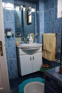 卡拉法特Hotel Casa Italia的蓝色瓷砖浴室设有水槽和镜子