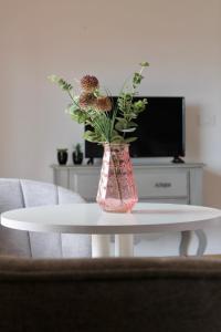 巴约讷Altos de Baiona - Habitación privada的白色桌子上花的粉红色花瓶